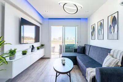 a living room with a blue couch and a table at Olympus Stylish 2-BR Apt & Balcony in Larnaca in Larnaka