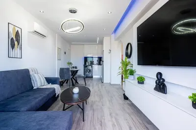 a living room with a couch and a tv on a wall at Olympus Stylish 2-BR Apt & Balcony in Larnaca in Larnaka