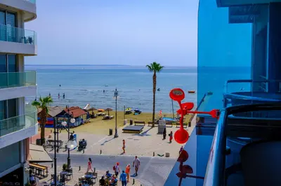 a view of a beach and the ocean from a building at Downtown Finikoudes Beach Apartment in Larnaka