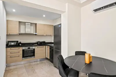 a kitchen with a table and chairs in a room at Downtown Finikoudes Beach Apartment in Larnaka