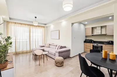 a living room with a couch and a table at Downtown Finikoudes Beach Apartment in Larnaka