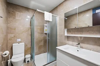a bathroom with a shower and a toilet and a sink at Downtown Finikoudes Beach Apartment in Larnaka