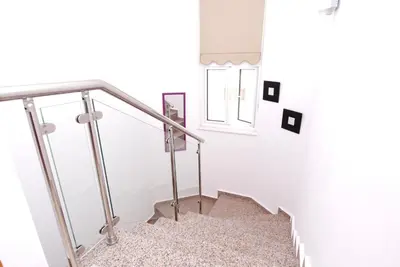 a staircase with a metal railing and a window at Maouris Villa in Protaras