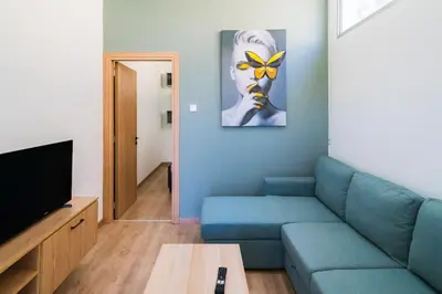 a living room with a blue couch and a television at Central Cosy Comfort Suite in Nicosia