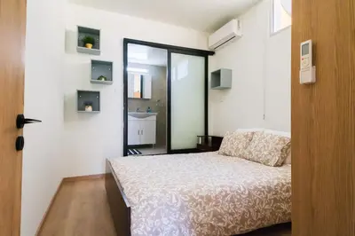 a small bedroom with a bed and a mirror at Central Cosy Comfort Suite in Nicosia