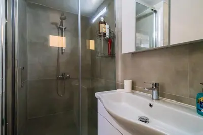 a bathroom with a shower and a sink and a mirror at Central Cosy Comfort Suite in Nicosia