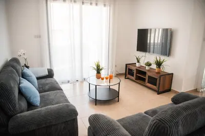 a living room with a couch and a tv at Villa Lela in Paralimni