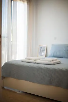 a bed with towels on top of it next to a window at Villa Lela in Paralimni
