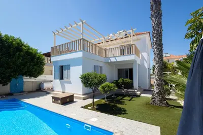 a villa with a swimming pool in front of a house at Maestro Villa II - Pervolia in Pervolia