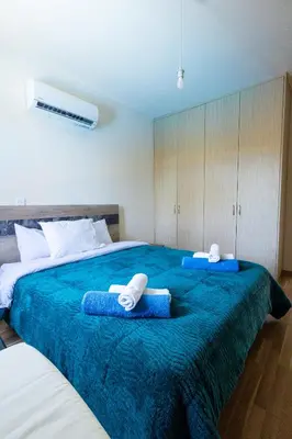 a bedroom with two beds with towels on them at Maestro Villa II - Pervolia in Pervolia