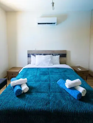 a bedroom with a blue bed with towels on it at Maestro Villa II - Pervolia in Pervolia