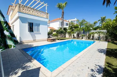 a swimming pool in front of a villa at Maestro Villa II - Pervolia in Pervolia