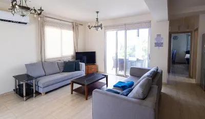 a living room with two couches and a tv at Maestro Villa II - Pervolia in Pervolia