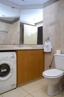 a bathroom with a washing machine and a sink at City Center Flat 23 in Larnaka