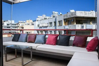 a white couch with colorful pillows on a balcony at City Center Flat 23 in Larnaka
