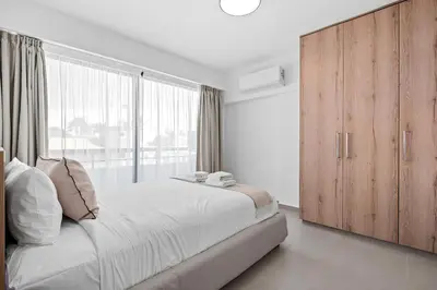 a bedroom with a large bed and a large window at Finikoudes Marina View 102 in Larnaka