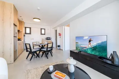 a living room with a tv and a table at Finikoudes Marina View 102 in Larnaka