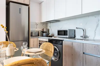 a kitchen with a table with chairs and a microwave at Lunette - Artful 1-BR Apartment & Balcony in Larnaca in Larnaka