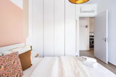 a bedroom with a bed with white walls at Lunette - Artful 1-BR Apartment & Balcony in Larnaca in Larnaka
