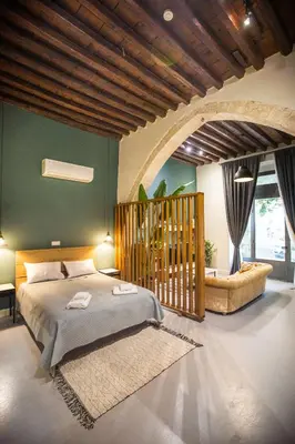 a bedroom with a bed and a green wall at Atelier Residences by Sweet Keys in Limassol
