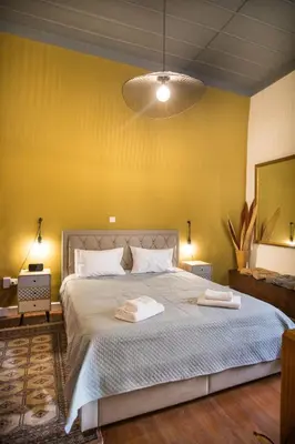 a bedroom with a large bed with a yellow wall at Atelier Residences by Sweet Keys in Limassol