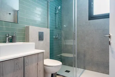 a bathroom with a toilet and a glass shower at Solenne - Stylish 2-BR Apartment & Balcony in Larnaca in Larnaka
