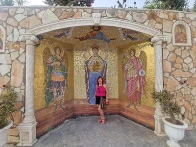 a woman standing in front of a wall with mosaics at Awaken Your Hidden Goddess Retreat at Nissi Avenue - Central Ayia Napa in Ayia Napa