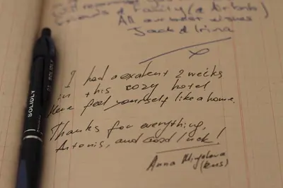 a pen sitting on top of a notebook with handwriting at Lima Sol House in Limassol