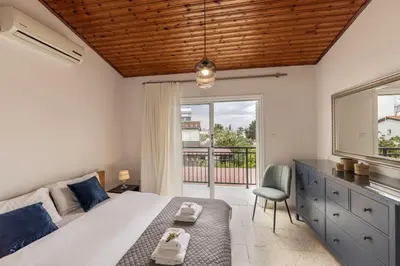 a bedroom with a bed and a window and a chair at Larnaca Seaside Villa Marina 43 in Pervolia