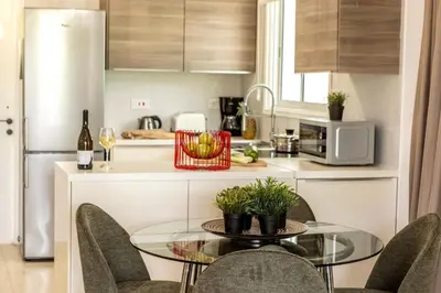 a kitchen with a glass table and chairs in a kitchen at Larnaca Seaside Villa Marina 43 in Pervolia