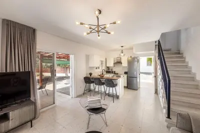 a living room with a staircase and a kitchen at Larnaca Seaside Villa Marina 44 in Pervolia