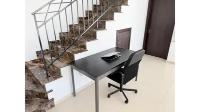 a desk with a chair next to a staircase at Bow Villa in Paralimni