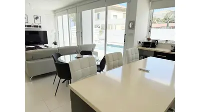 a kitchen and living room with a table and chairs at Bow Villa in Paralimni