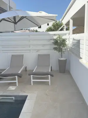 two chairs and an umbrella on a patio at Bow Villa in Paralimni