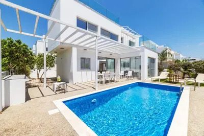a villa with a swimming pool and a house at Elite Blu Heights Villa in Ayia Napa