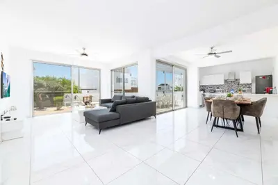 a white living room with a couch and a table at Elite Blu Heights Villa in Ayia Napa