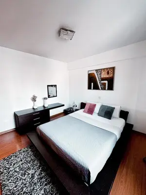 a bedroom with a large white bed and a rug at Ikarus in Limassol