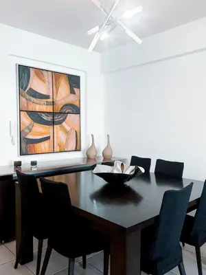 a dining room table with chairs and a painting at Ikarus in Limassol