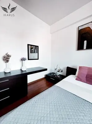 a white bedroom with a bed and a desk at Ikarus in Limassol