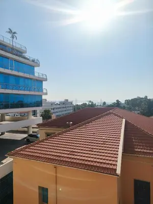 a building with a red roof and a blue building at Marina City Centre Stays in Larnaka
