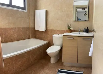 a bathroom with a toilet and a tub and a sink at Makriev Suite in Larnaka