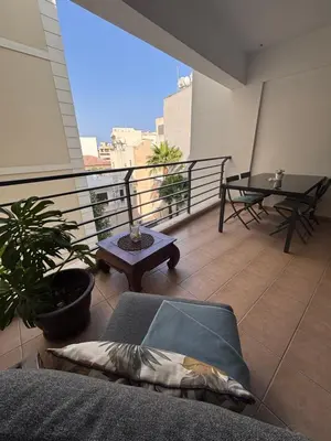 a balcony with a couch and a table on a building at Makriev Suite in Larnaka
