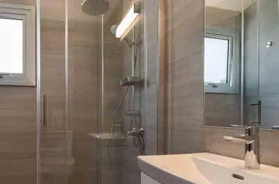 a bathroom with a shower with a sink and a mirror at Phaedrus Living Travertine Residences 101 in Strovolos