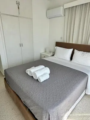 a bedroom with a bed with towels on it at Sunrise Maisonette in Voroklini