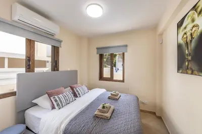 a bedroom with a bed with two towels on it at Villa Poseidon in Paralimni