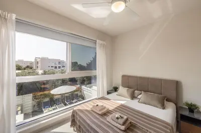 a bedroom with a bed and a large window at Milan's Mythical Villa in Paralimni
