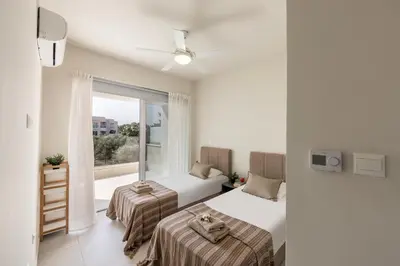 two beds in a room with a window at Milan's Mythical Villa in Paralimni