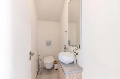 a white bathroom with a toilet and a sink at Milan's Mythical Villa in Paralimni