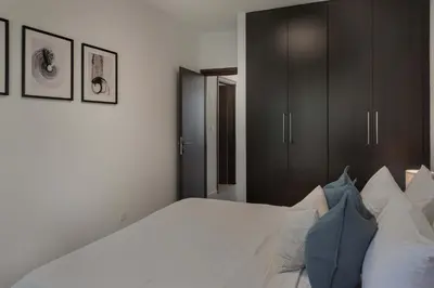 a bedroom with a large white bed with blue pillows at Phaedrus Living Travertine Residences 102 in Strovolos