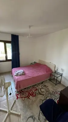 a bedroom with a pink bed and a rug at Kyrenia 2 bedroom apartment in Ayios Dhometios